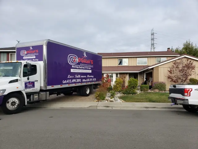 Joshua's Moving truck parked in front of a house on move day